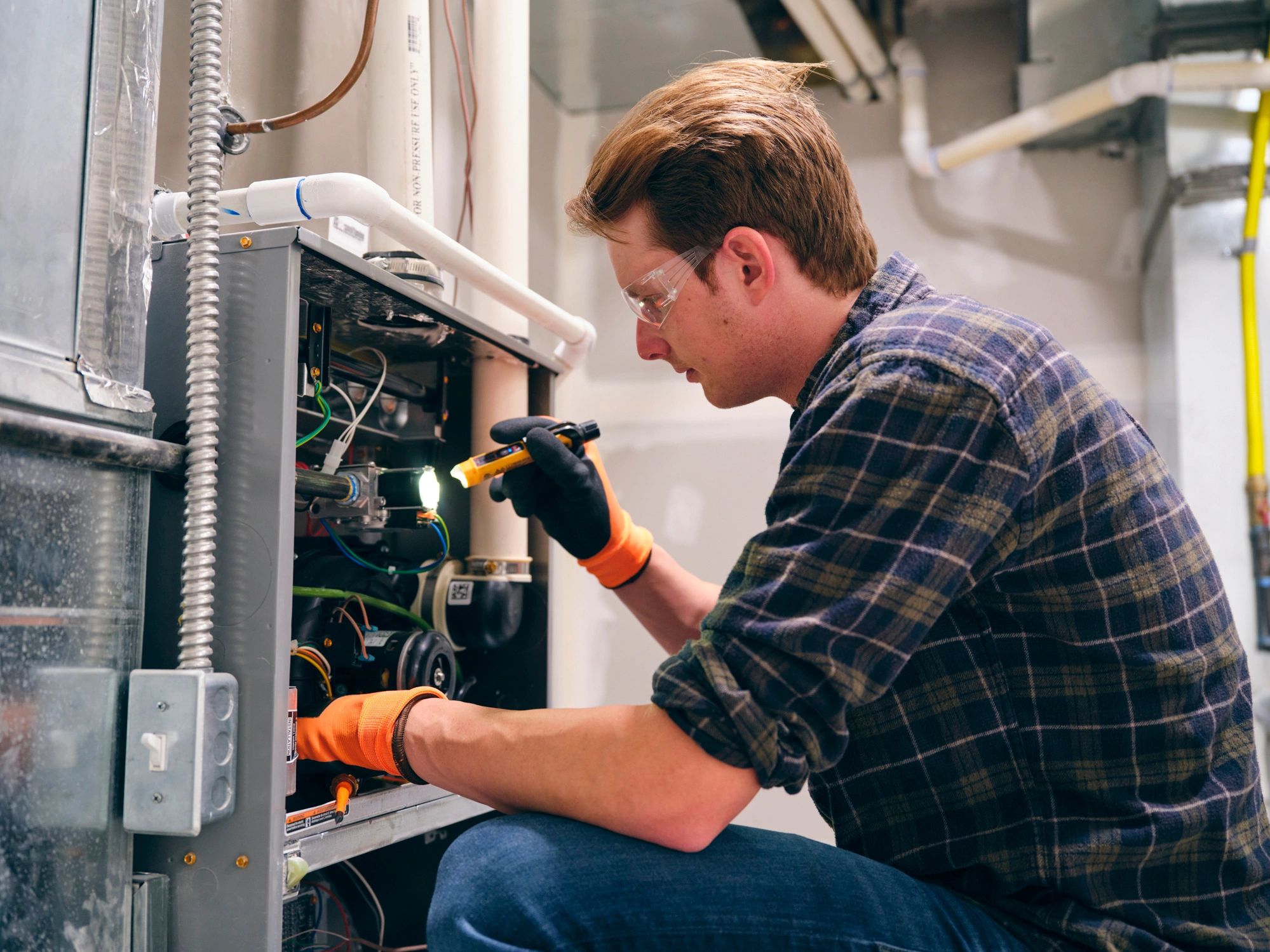 Technician inspecting a furnace during a home service visit