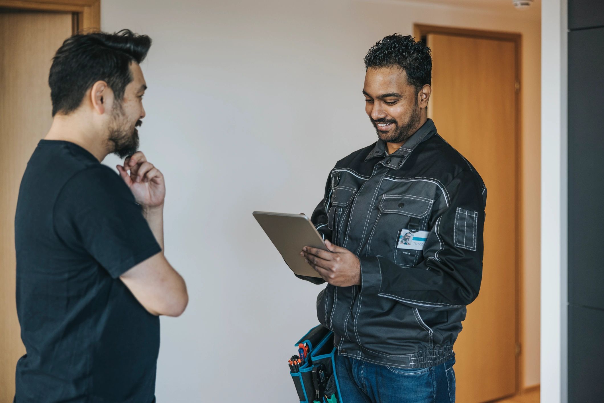 HVAC technician speaking with a customer while reviewing details on a tablet