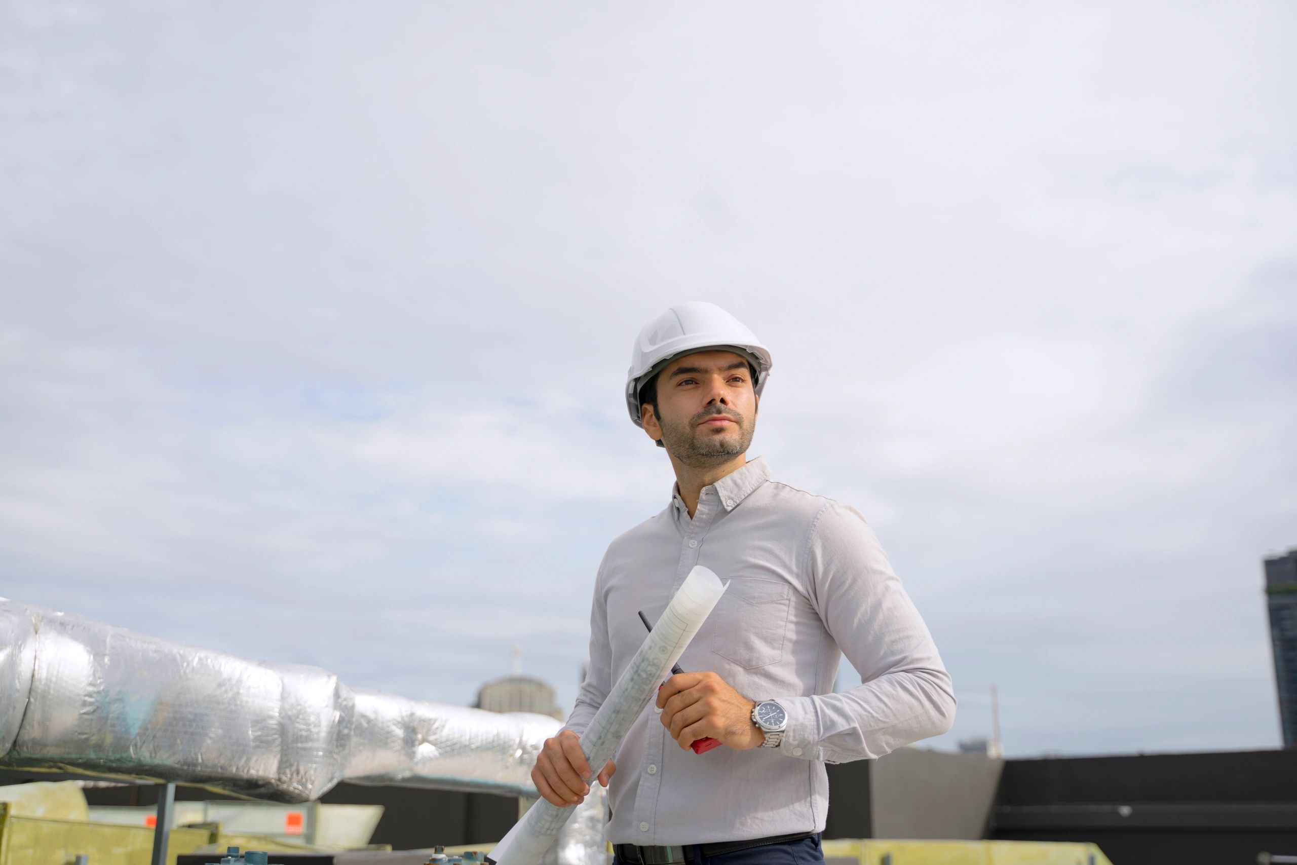 Technician working on rooftop HVAC equipment in an urban setting